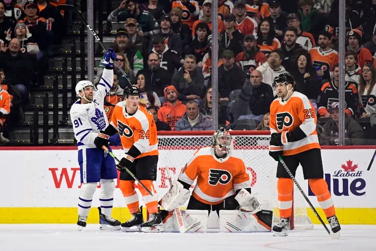 Toronto Maple Leafs' John Tavares, left, celebrates a goal scored by teammate Conor Timmins past Philadelphia Flyers goaltender Carter Hart, second from right, during the second period of an NHL hockey game, Sunday, Jan. 8, 2023, in Philadelphia. (AP Photo/Derik Hamilton)