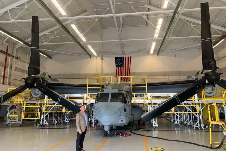 Boeing plant executive Shane Openshaw with a V-22 Osprey in 2022. Stripped and painted, it awaited flight testing on a hangar facing the Delaware River at the company's factory in Ridley Park, Delaware County.