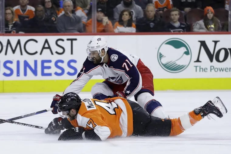 Flyers defenseman Andrew MacDonald (bottom) and Blue Jackets forward Nick Foligno battle for the puck during the third period of the Flyers’ loss.