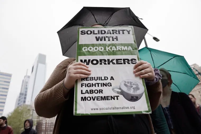 A person holds a sign supporting coffee workers at Good Karma Cafe during a rally, at City Hall, to support unionization among coffee workers in Phila., Pa. on May 1, 2022.