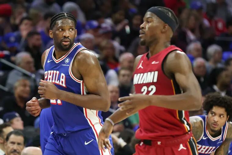 Philadelphia 76ers center Joel Embiid runs next to Miami Heat forward Jimmy Butler in the second quarter of an NBA play-in tournament game at the Wells Fargo Center in Philadelphia on Wednesday, April 17, 2024.