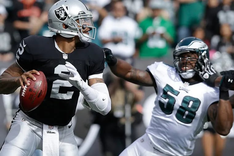 Raiders quarterback Terrelle Pryor (2) drops back to pass as Philadelphia Eagles outside linebacker Trent Cole (58) applies pressure during the first quarter of an NFL football game in Oakland, Calif., Sunday, Nov. 3, 2013. (Jeff Chiu/AP)