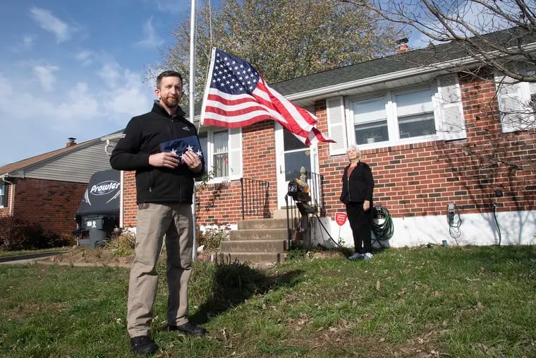 David Pinder, a Navy Veteran, is photographed practicing social distancing  after installing an American flag at the home of Janet Stutzman in New Castle, DE. Thursday, November 19, 2020. About three years ago, Dave started knocking on his neighborÕs doors, offering to decommission their old American Flags and replace them with a new ones for free.