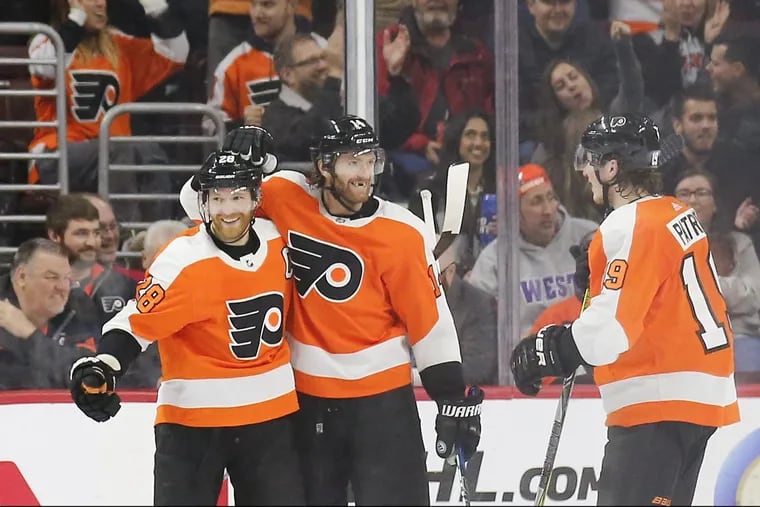 Flyers center Claude Giroux celebrates his second-period power play goal with teammates center Sean Couturier (center) and Nolan Patrick (right) against the New York Rangers on Saturday.