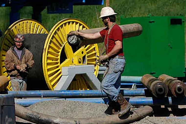 Doug Stough (left), and Joe Rivera, with Ziegenfuss Drilling of Ringoes, N.J., unload drill rod for their rotary drill. (Michael S. Wirtz/File)