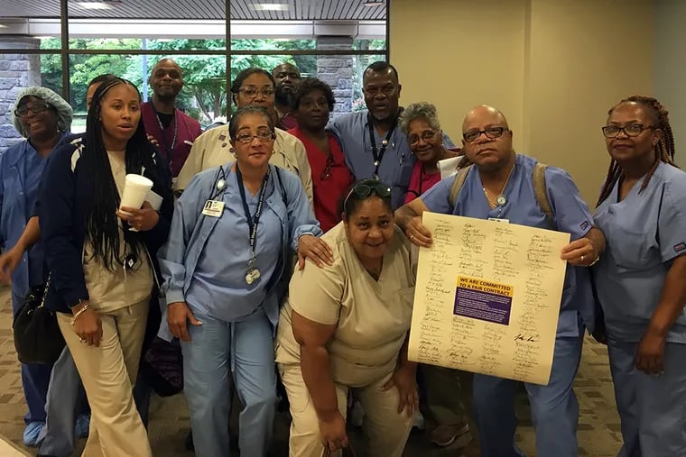 Workers at Chestnut Hill Hospital with the petition they delivered to management in July. They just ratified a three-year contract with new owners Tower Health.
