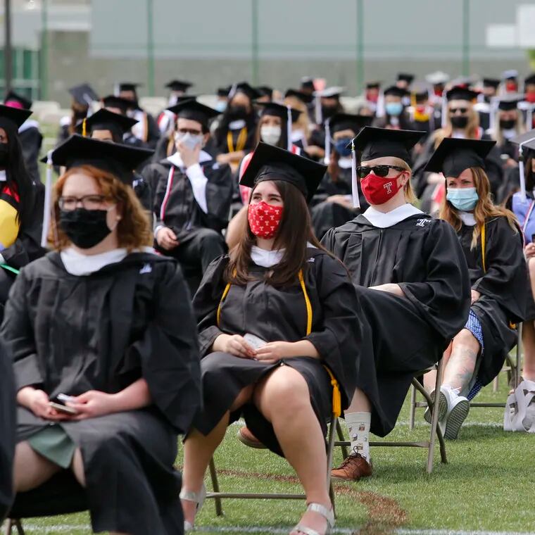 Masked Temple University graduates take their seats during the College of Liberal Arts commencement in 2021. Pandemic-induced work changes and a smaller generation coming into college age raises questions for Philadelphia as stakeholders aim to continue a trend of more college-educated young adults staying in the area.