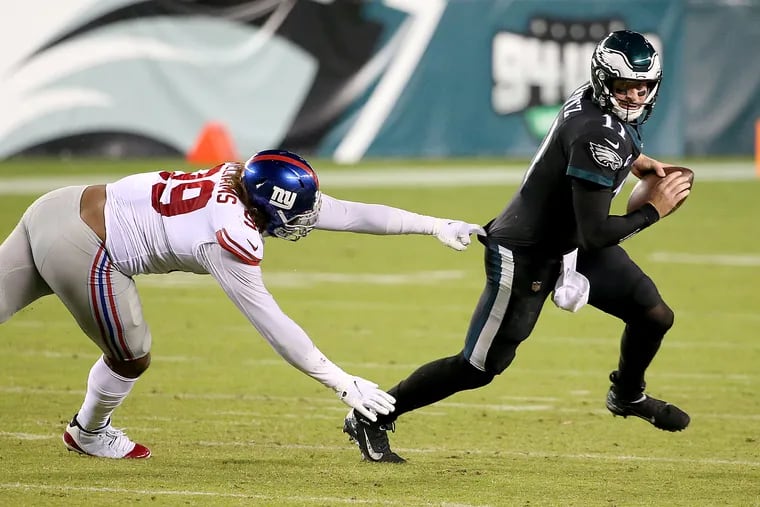 Wentz (right) scrambles away from Giants defensive end Leonard Williams in the second quarter.