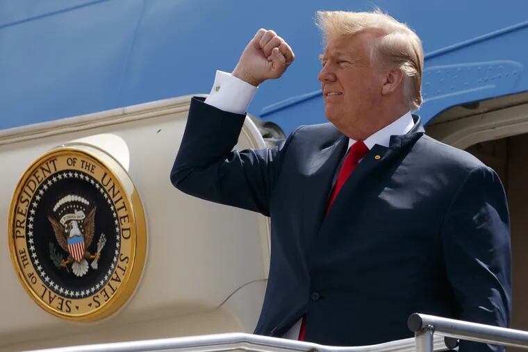 President Trump pumps his fist as he steps off Air Force One on May 31 after arriving at Ellington Field Joint Reserve Base, in Houston. On Tuesday, he canceled the Philadelphia Eagles planned White House visit in a dispute over demonstrations during the national anthem. 