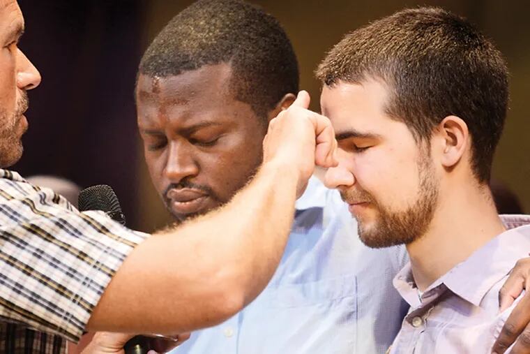 Pastor Bob Meyers (left) anoints Michael Wortell (right) and Rob Chifokoyo (left) with oil as they pray with family, friends and the congregation during services at Doylestown's Covenant Church, Aug. 24, 2014. (TOM GRALISH/Staff Photographer)