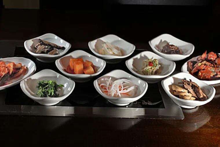 An array of banchan— pickled nibbles, many made from ingredients harvested from the home garden of Miga owners Sam and Jackie Cho — comes to every table before the entree is served. (DAVID M WARREN / Staff Photographer)
