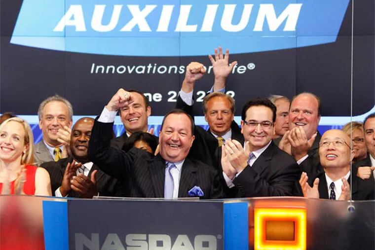 Better days? Officials for drug maker Auxilium ring the opening bell on June 25, 2012. (Photo from Nasdaq.com)