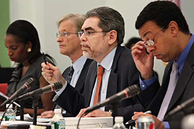 Chairman Pedro Ramos (center) at the School Reform Commission meeting. He stressed that the renewal votes were merely the first steps in a lengthy process. STEVEN M. FALK / Staff Photographer