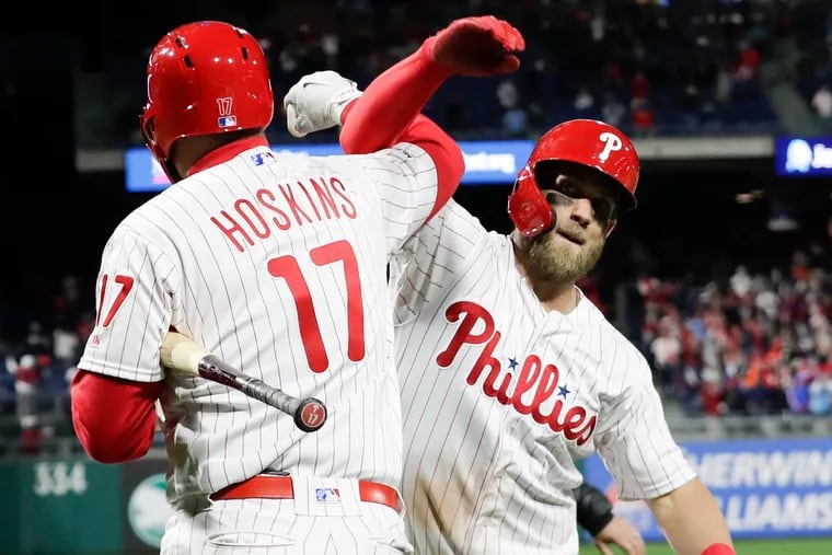 Bryce Harper celebrating with Rhys Hoskins after Harper's home run against the Braves on Sunday.