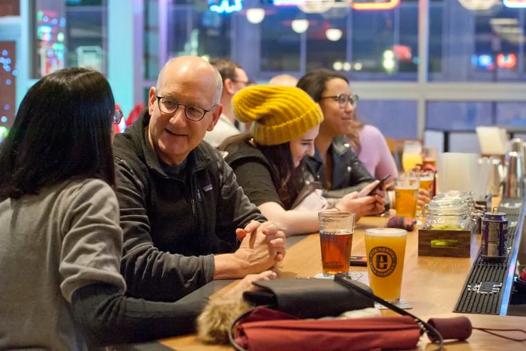 Patrons enjoy good drink and conversation at the bar of the The Post at Cira Garage in West Philadelphia, February 23, 2019.