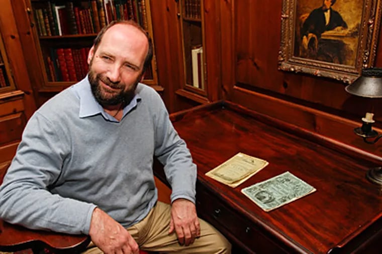 Gerald Dickens sits at his great-great-grandfather's desk at the Free Library, where two exhibits mark next year's bicentennial of Charles Dickens' birth. (Michael S. Wirtz / Staff Photographer)