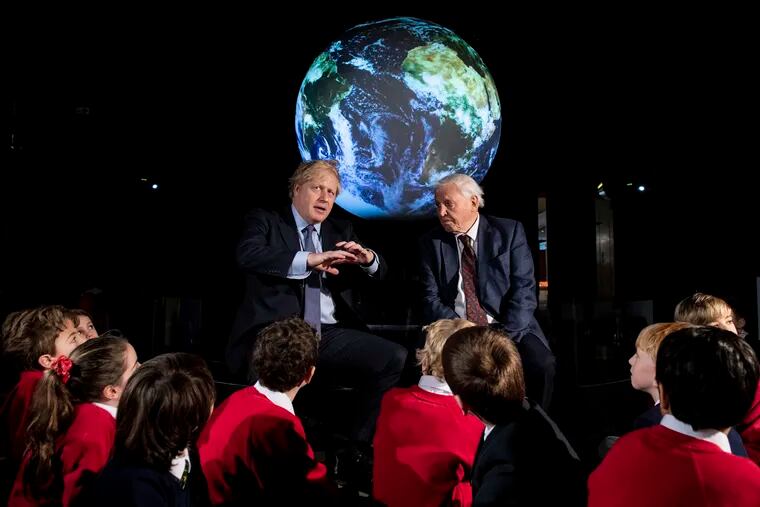 Britain's Prime Minister Boris Johnson, left, and David Attenborough speak with school children in February during the launch of what was supposed to be the UK-hosted COP26 UN Climate Summit in London.