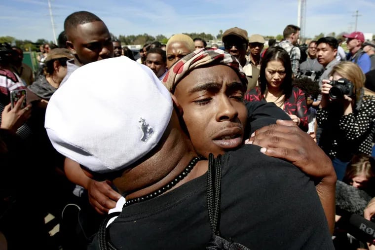Stevante Clark, the brother of police shooting victim, Stephon Clark, is hugged by a supporter after Stephon Clark's funeral Thursday, March 29, 2018, in Sacramento, Calif. Stephon Clark who was unarmed, was shot and killed by Sacramento Police Officers, Sunday, March 18, 2018.
