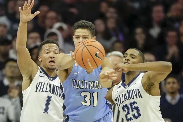 Columbia forward Myles Hanson passes the basketball double-teamed by Villanova guard Jalen Brunson (left) and guard Mikal Bridges during the first half of their season opener on Friday.