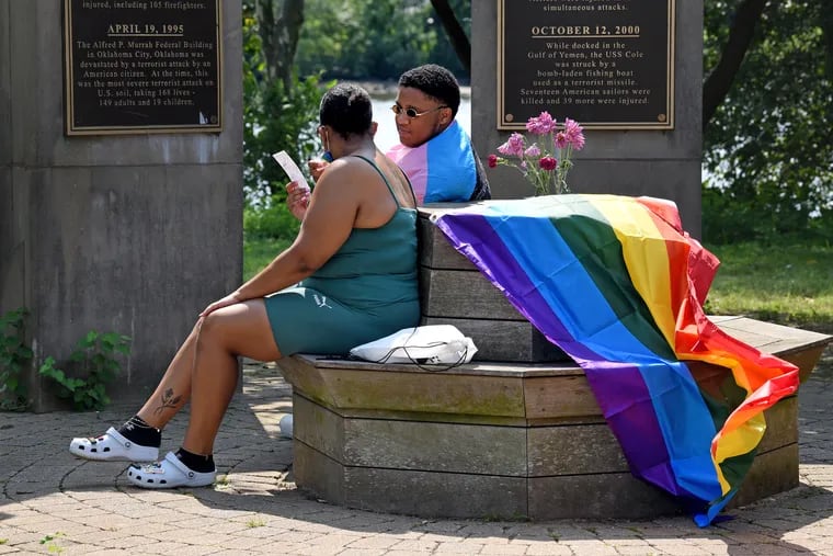 Cousins Kaleyse Hamilton of Deptford (left) and Adrian Hagans of Blackwood (right) look over their photos, sitting inside the Victims of Terrorism Memorial, after getting their selfie taken at an adjacent booth on Sept.12, 2021, during the 13th annual Jersey Gay Pride Festival in Camden County's Cooper River Park.