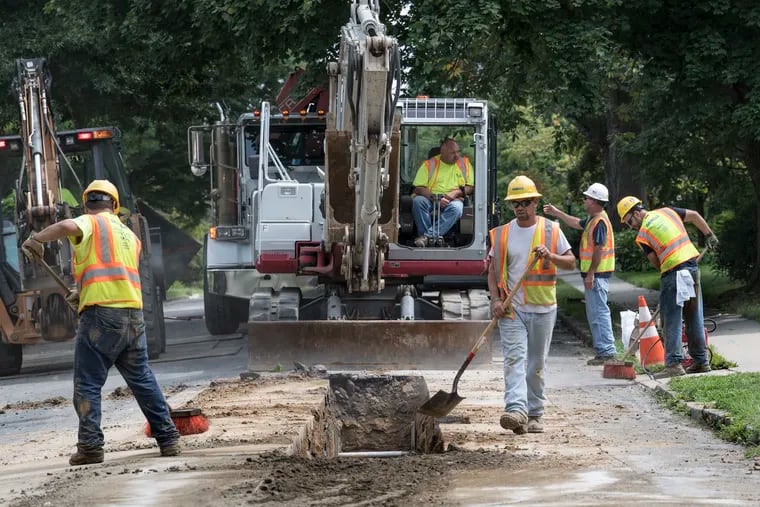 Aqua America workers rebuild a water main in Upper Darby. Aqua is buying the Delaware County sewage system from a regional authority, DELCORA, a transaction that has come under fire from newly elected Democrats who now control the county.