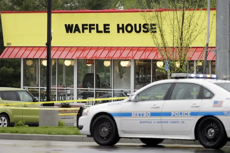 A police car sits in front of a Waffle House restaurant in Nashville, Tenn. Four people died after a gunman opened fire at the restaurant early Sunday.