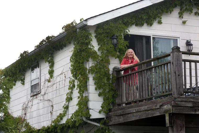 Elaine Scattergood stands at her house in Avalon, N.J. She received a citation in January for her Virginia creeper vines that grow across her home.