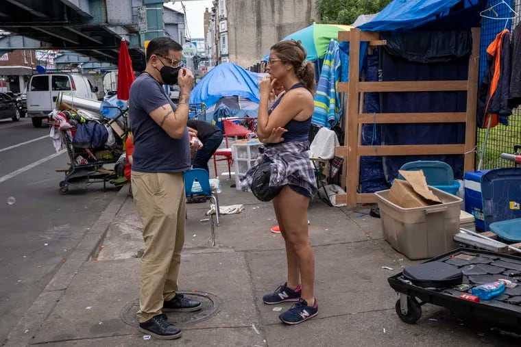 Gilberto Gonzalez, (left) activist and candidate for congress Pennsylvania 2nd Congressional District speaks with Stephanie Sena, Anti Poverty Fellow at Villanova University Charles Widger School of Law, near a tent camp along Kensington Avenue on Wednesday, August 4, 2021.