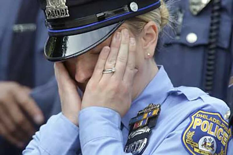 A Philadelphia police officer reacts during funeral services for slain Philadelphia police Officer Patrick McDonald today. (Matt Rourke/Associated Press)