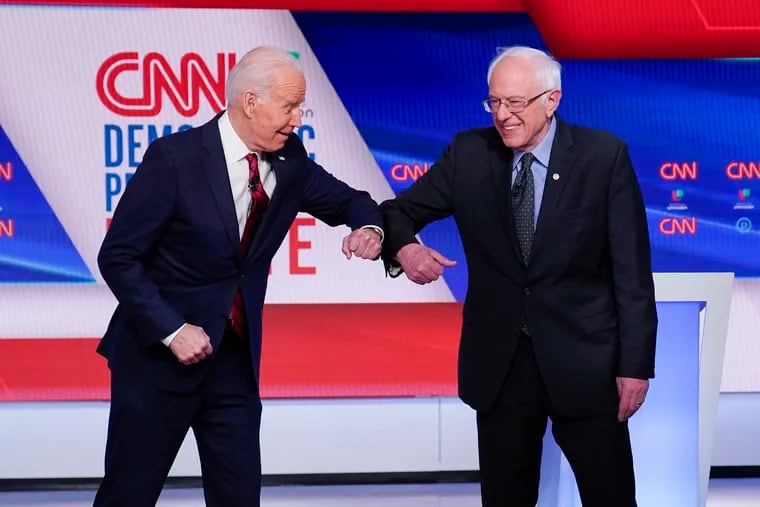 Former Vice President Joe Biden and Sen. Bernie Sanders greet one another before a Democratic presidential primary debate in Washington, Sunday, March 15, 2020.