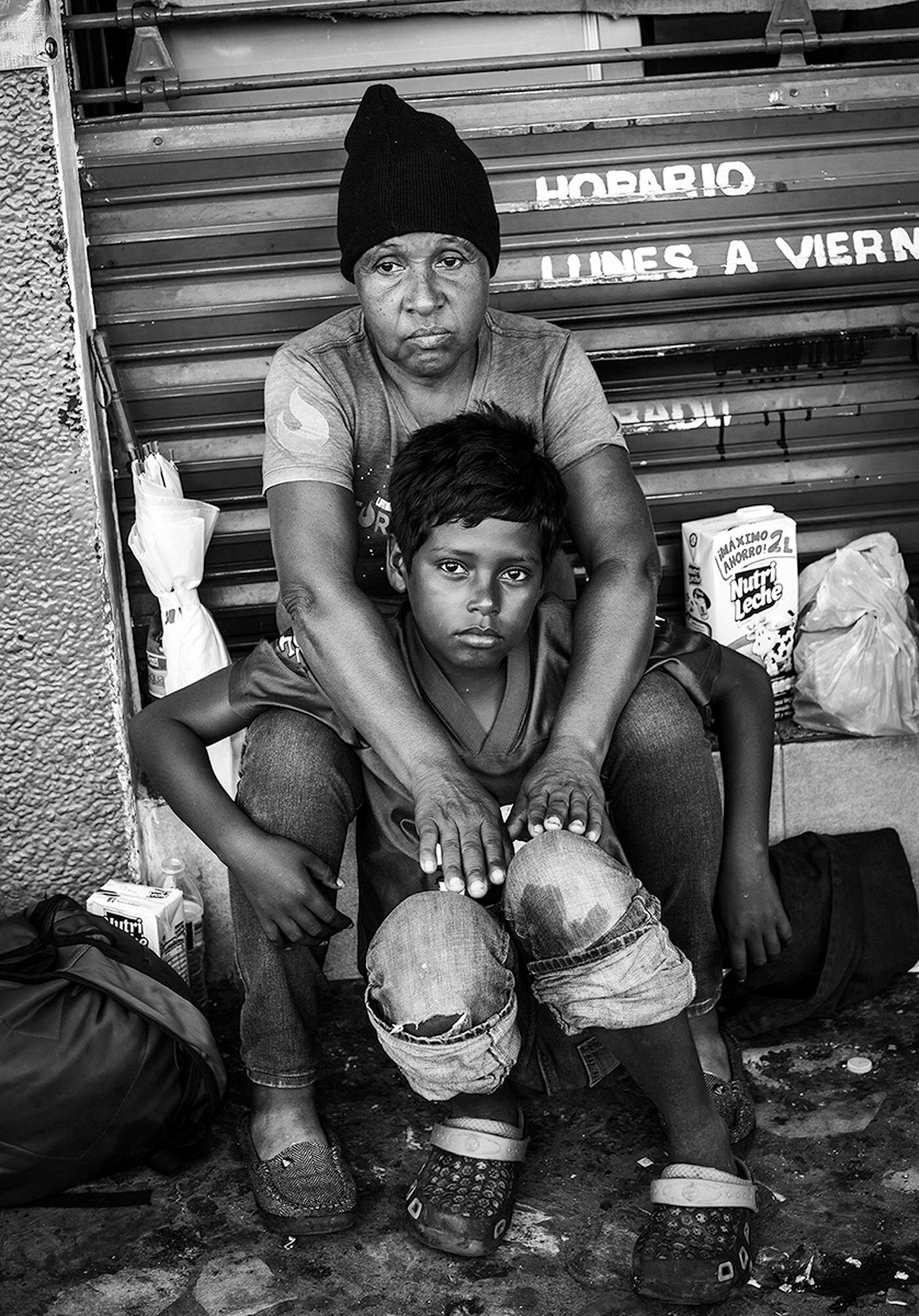On the road with the migrant caravan, a mother and her young son pause during the grueling trek.