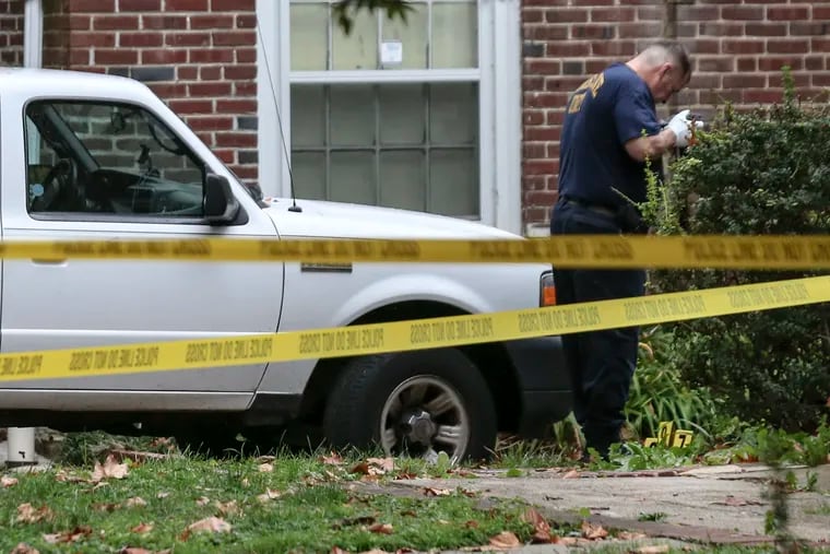 Crime scene investigators work where a Philadelphia police officer was shot in the leg and a possible suspect was shot dead in the city's Overbrook section just after 3:15 p.m. in a driveway along the 5700 block of Overbrook Avenue on Tuesday.