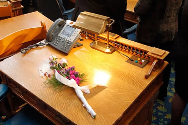 Two pink roses wrapped in a ribbon on the desk of Alex DeCroce, the top Assembly Republican, who died Monday. (Akira Suwa / Staff Photographer)