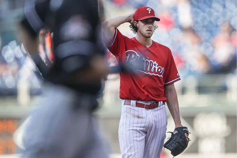 Phillies pitcher Aaron Nola reacts after the Marlins’ Ichiro Suzuki rounds the bases while hitting a three-run homer in Tuesday’s first game.