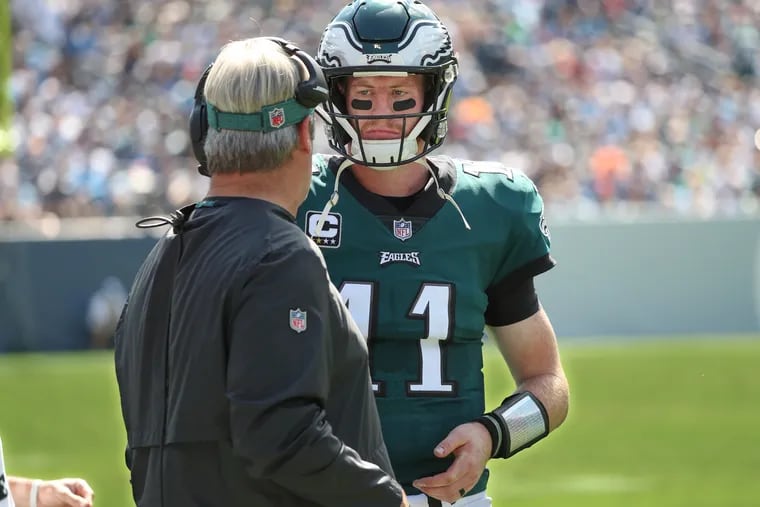 Eagles quarterback Carson Wentz confers with head coach Doug Pederson before taking the field on offense during the second quarter of the game against the Titans on on Sunday September 30, 2018. MICHAEL BRYANT / Staff Photographer