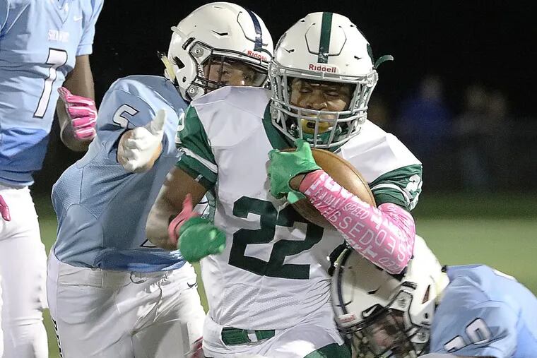 Camden Catholic’s Tyrese Ware (center) gets wrapped up by Shawnee’s Tommy Kane (right).