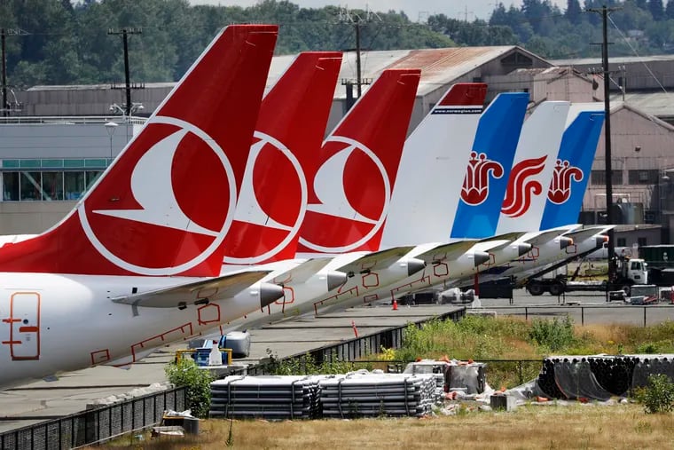 The tails of several of the dozens of grounded Boeing 737 MAX airplanes line the edge of a parking area adjacent to Boeing Field Thursday, June 27, 2019, in Seattle. A new software problem has been found in the troubled Boeing 737 Max that could push the plane's nose down automatically, and fixing the flaw is almost certain to further delay the plane's return to flying after two deadly crashes. Boeing said Wednesday, June 26, 2019, that the FAA "identified an additional requirement" for software changes that the aircraft manufacturer has been working on for eight months, since shortly after the first crash. (AP Photo/Elaine Thompson)