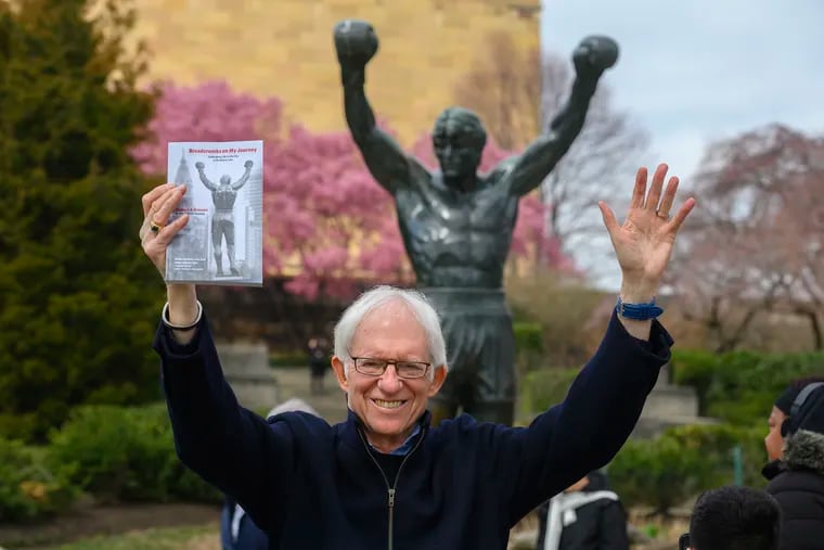Author and Philadelphia native Richard G. Krassen stands near the Rocky statue at the Philadelphia Museum of Art holding his book "Breadcrumbs on My Journey, Celebrating Life in the City of Brotherly Love," in March.