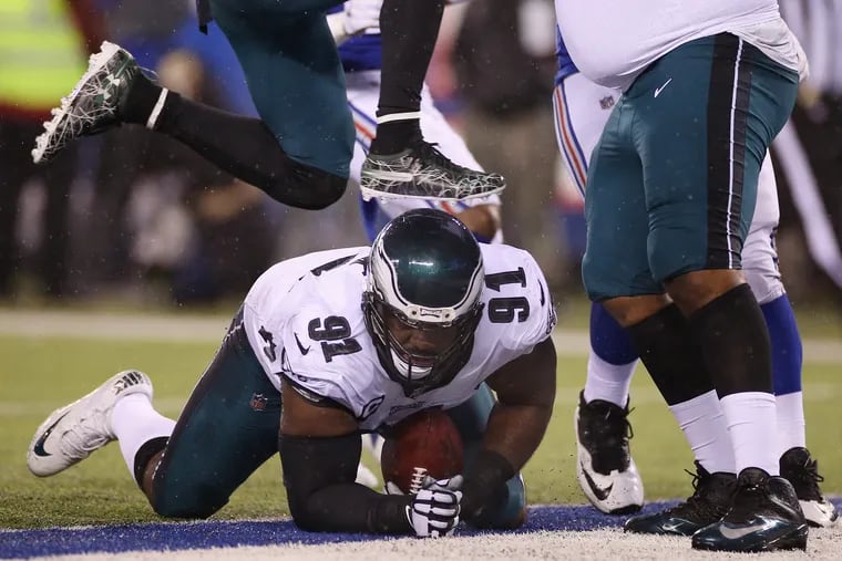 Eagles defensive tackle Fletcher Cox (91) recovers a fumble by New York Giants quarterback Daniel Jones (8) in the fourth quarter of Sunday's 34-17 Eagles win, which clinched a playoff spot for them.