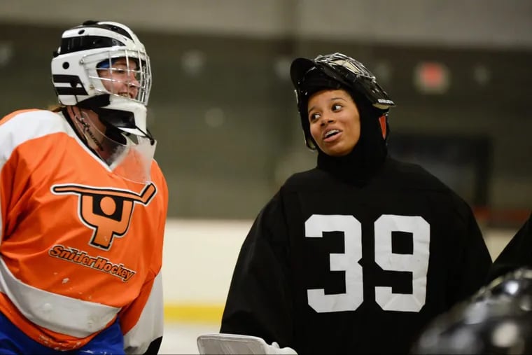 Maryam Belgrave (right) jokes with a fellow goalkeeper at practice .