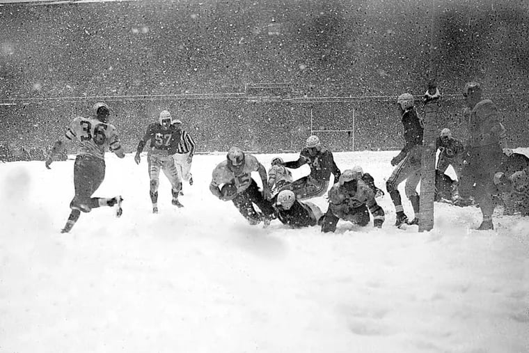Steve Van Buren (15) of the Philadelphia Eagles plunges over the goal line with a fourth period touchdown that defeated the Chicago Cardinals in the driving snowstorm in Philadelphia, Pa., Dec. 1948.  Other players are, Bill Blackburn (57) and John Cochrane (24) of the Cardinals. (AP Photo)