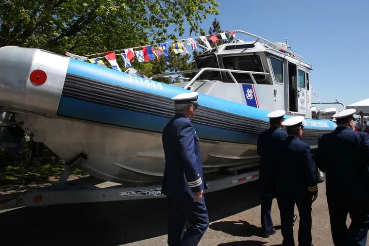 On their way to the ceremony to launch construction of the project, Coast Guard members pass a 31-foot boat donated by Marcus Hook Borough.