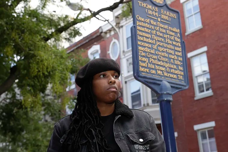 Philadelphia artist Mary Enoch Elizabeth Baxter stands next to the Thomas Eakins historical marker in front of Eakins' Spring Garden neighborhood house on Monday, October 18, 2021.