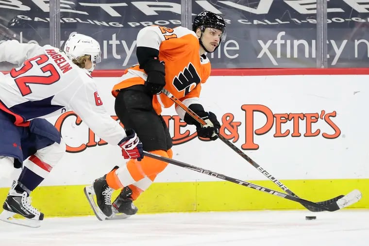 Flyers forward Scott Laughton skates after the puck past Washington Capitals left wing Carl Hagelin on Sunday. Laughton has raised his play the last two seasons and could be protected in the expansion draft.