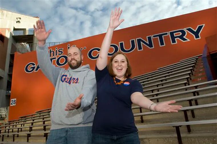 Alison and Mike Hightower show the "gator chop" while standing  in the University of Florida's Ben Hill Griffin stadium in  Gainesville, Fla., Friday, Dec. 5, 2008. The two UF students  took advantage of  a university offer where students  can apply to get an additional season football ticket for their spouse.  (AP Photo/Phil Sandlin)