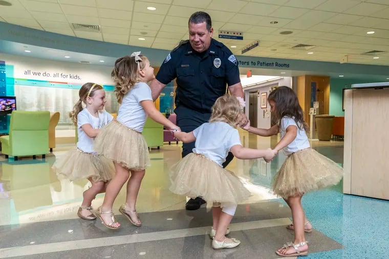 Security guard David Dean dances with McKinley Moore, Avalynn Luciano, Lauren Glynn, and Chloe Grimes at Johns Hopkins All Children's Hospital in St. Petersburg, Fla., in 2018 The girls, who were diagnosed with cancer in 2016 and became fast friends while undergoing treatment, reunite every year.