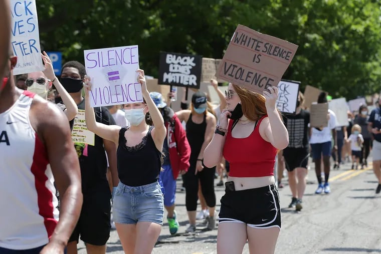 Megan McNamara (right), 19, of Wayne, walks up Lancaster Avenue during The Main Line for Black Lives protest in Wayne, Pa. on June 4, 2020.