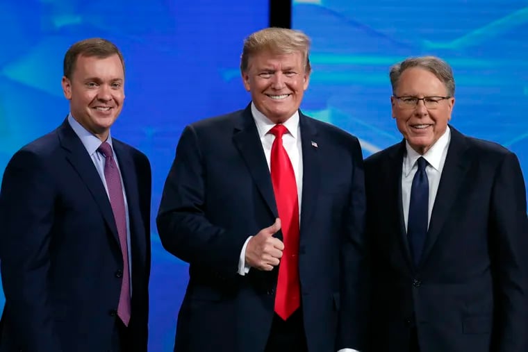 President Donald Trump in April poses with NRA-ILA Executive Director Chris Cox (left) and executive Vice President Wayne LaPierre before speaking at the National Rifle Association Institute for Legislative Action Leadership Forum in Lucas Oil Stadium in Indianapolis. The president has abandoned the idea of releasing proposals to combat gun violence that his White House debated for months following mass shootings in August.