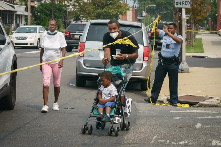 Ramone Harris picks up his son Sekani Brown-Harris from Pee Wee Prep Educational Center, which provides childcare and academic enrichment programs for school-age children, and is on the same block as a triple shooting that occurred at 56th and Vine Streets, in West Philadelphia, July 21, 2021. .