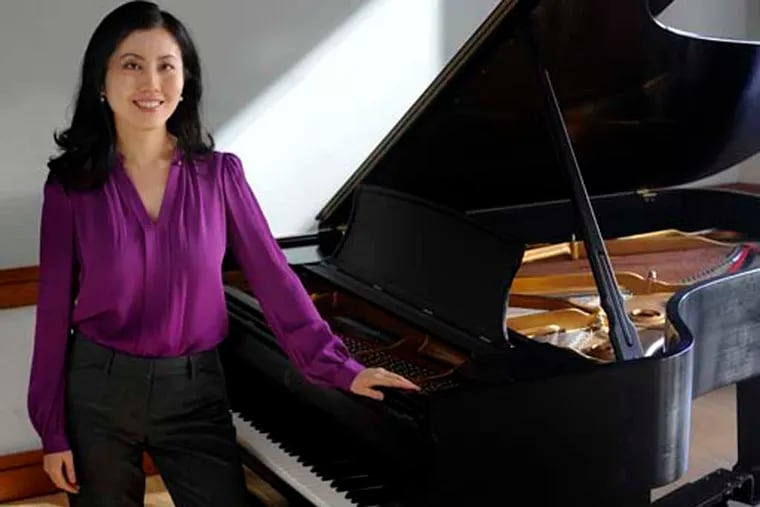 Dr. Chia-jung Tsay poses with a grand piano at Curtis Institute of Music November 19, 2014. She is a visiting professor in business management at Wharton - but she's also a classically trained pianist (both Juilliard and Peabody) and is the author of a study that claims in music competitions, even the experts judge on what they see rather than what they hear. ( TOM GRALISH / Staff Photographer )